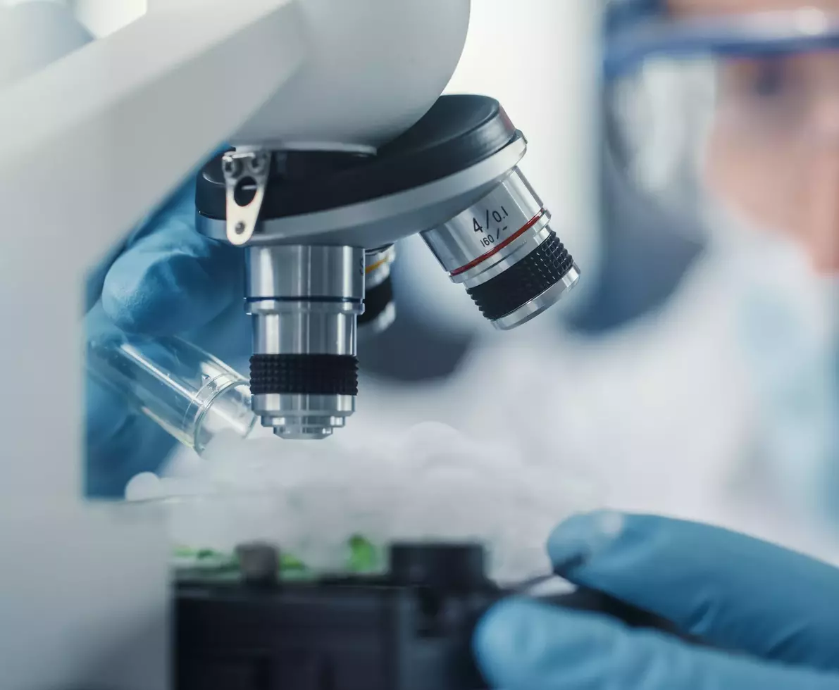 researcher looking through microscope