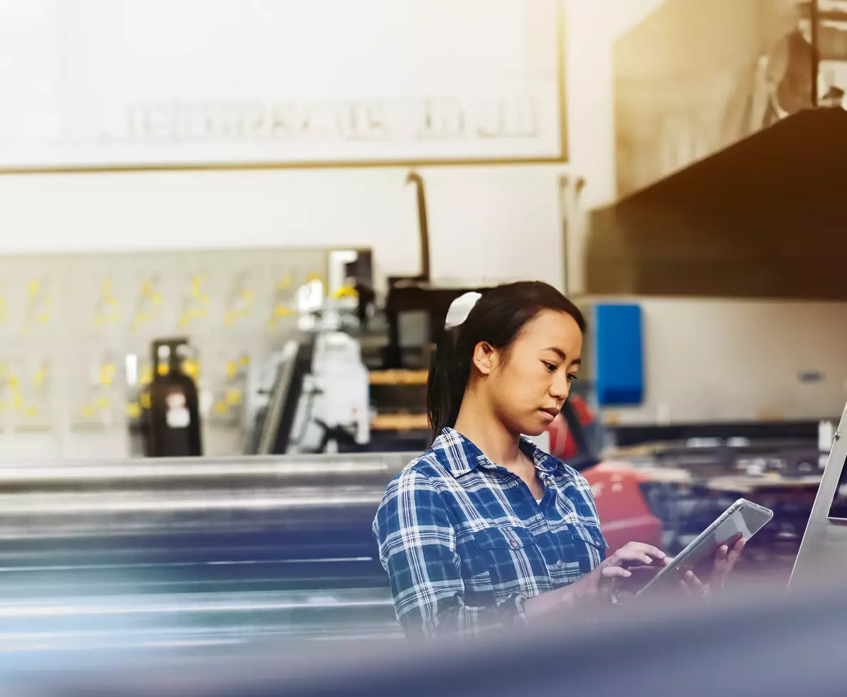 woman inputting into a tablet to operate machinery  