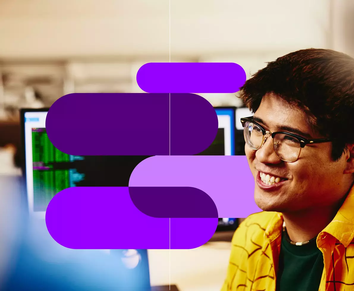 smiling man sitting in front of computer